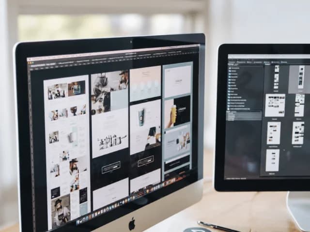 Two monitors showing page layouts in design software